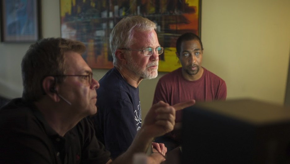 Editor George Artope, Director Peter Brosnan,and Producer Daniel J. Coplan sift through 30 years of footage. Photo by Kelvin Jones.